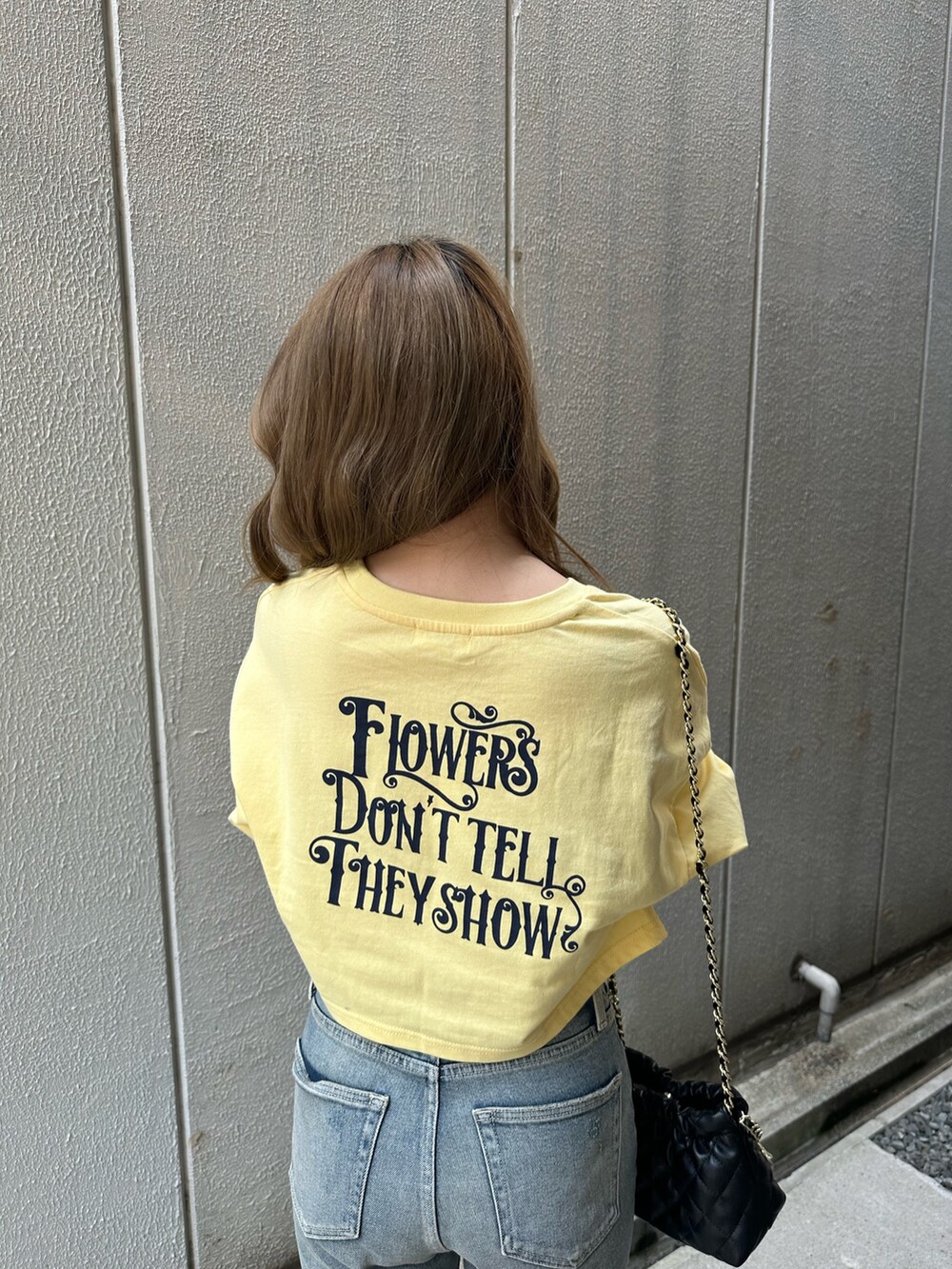 イエロー系のTシャツ/カットソー、ブルー系のデニムパンツ、ブラック系のショルダーバッグを着用したレディースの春コーディネートの5枚目の写真