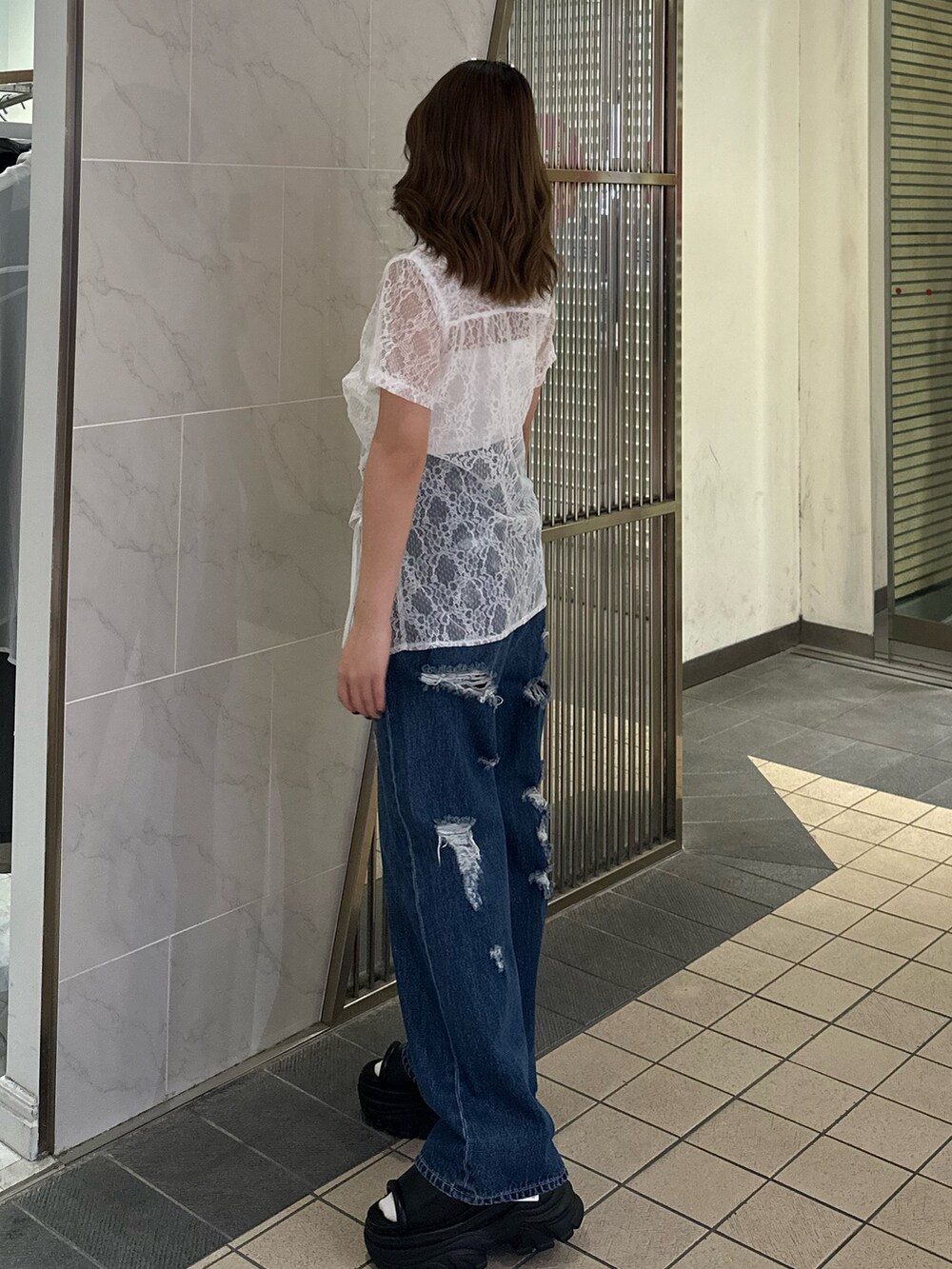 ホワイト系のシャツ/ブラウス、ブルー系のデニムパンツ、ブラック系のサンダルを着用したレディースの春コーディネートの2枚目の写真