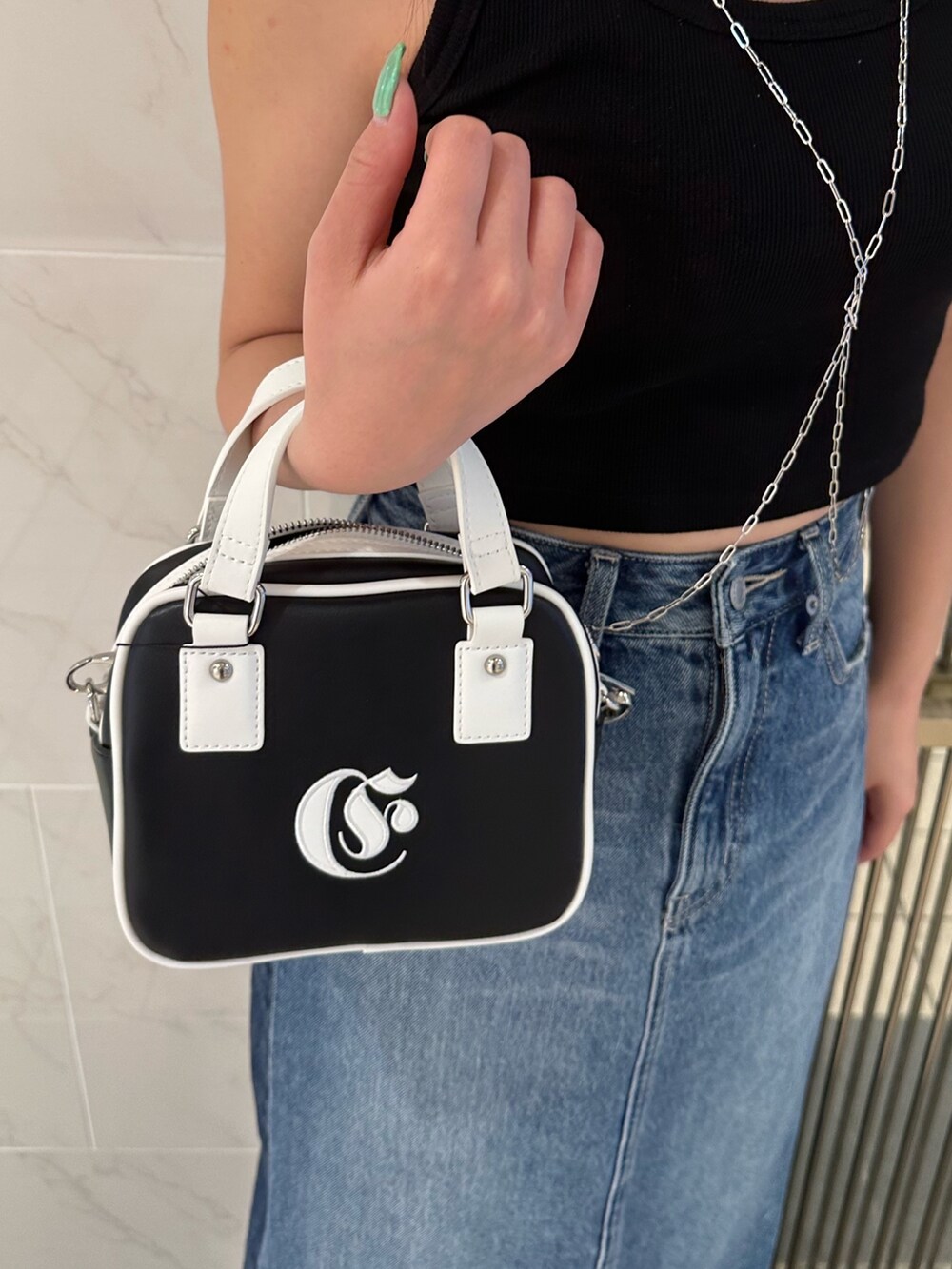 ブルー系のデニムスカート、ブラック系のタンクトップ、ブラック系のサンダルを着用したレディースの春コーディネートの7枚目の写真