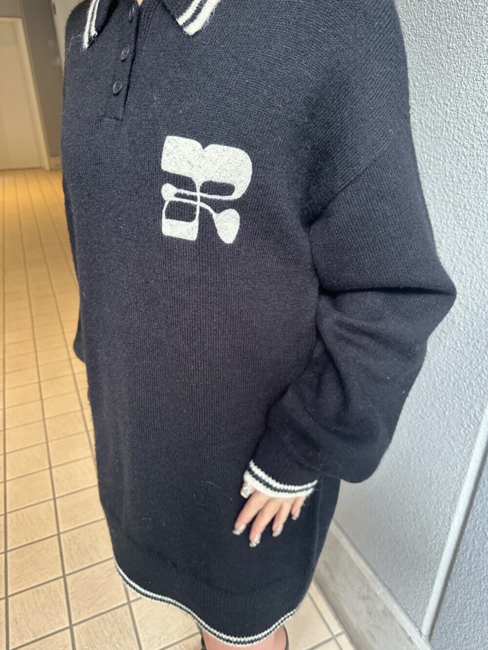 ブラック系のブーツ、ブルー系のデニムスカート、ブラック系のニット/セーターを着用したレディースの冬コーディネートの6枚目の写真