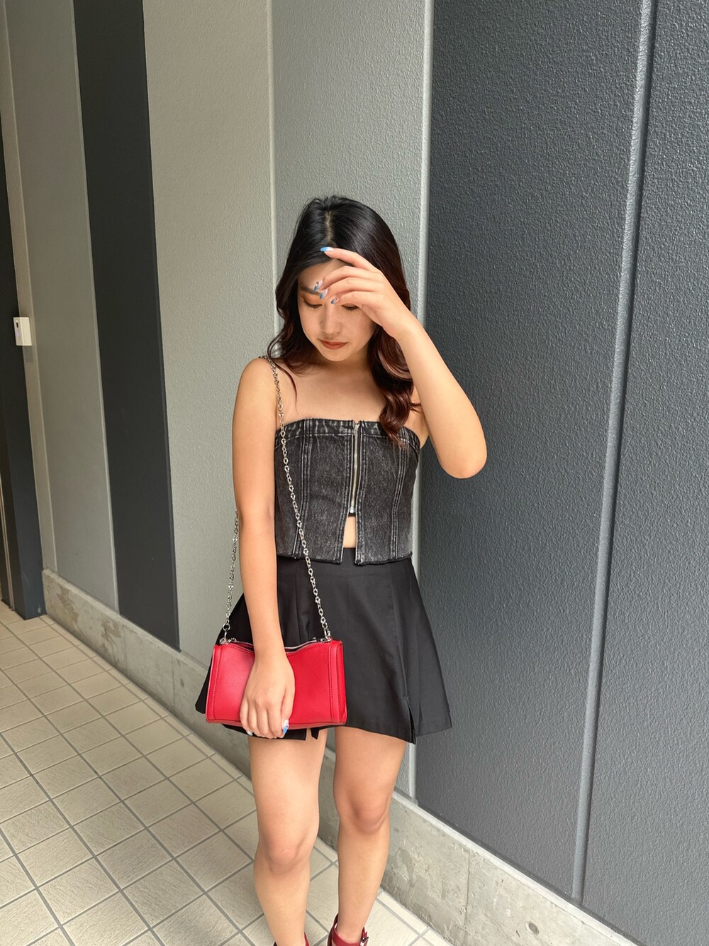 ブラック系のスカート、レッド系のショルダーバッグ、レッド系のサンダルを着用したレディースの夏コーディネートの5枚目の写真