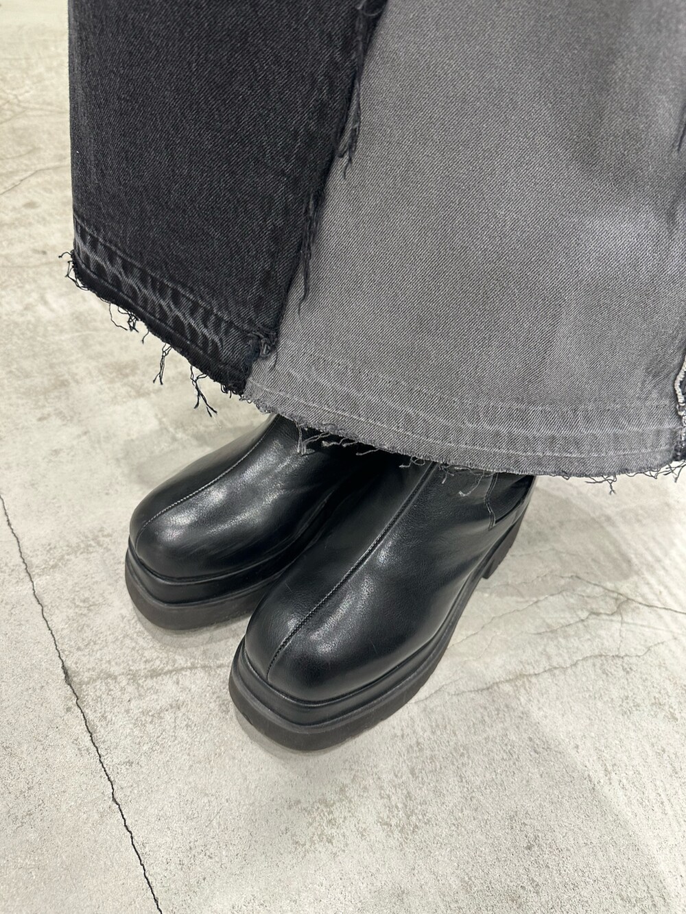 ブラック系のデニムスカート、ブラック系のニット/セーター、ブラック系のブーツを着用したレディースの冬コーディネートの8枚目の写真