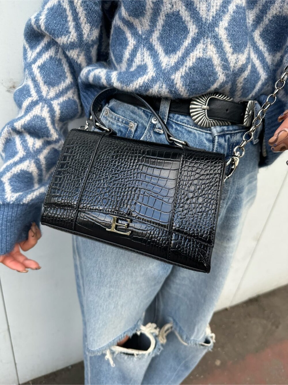 ブラック系のブーツ、ブルー系のニット/セーター、ブルー系のデニムパンツを着用したレディースの秋コーディネートの6枚目の写真