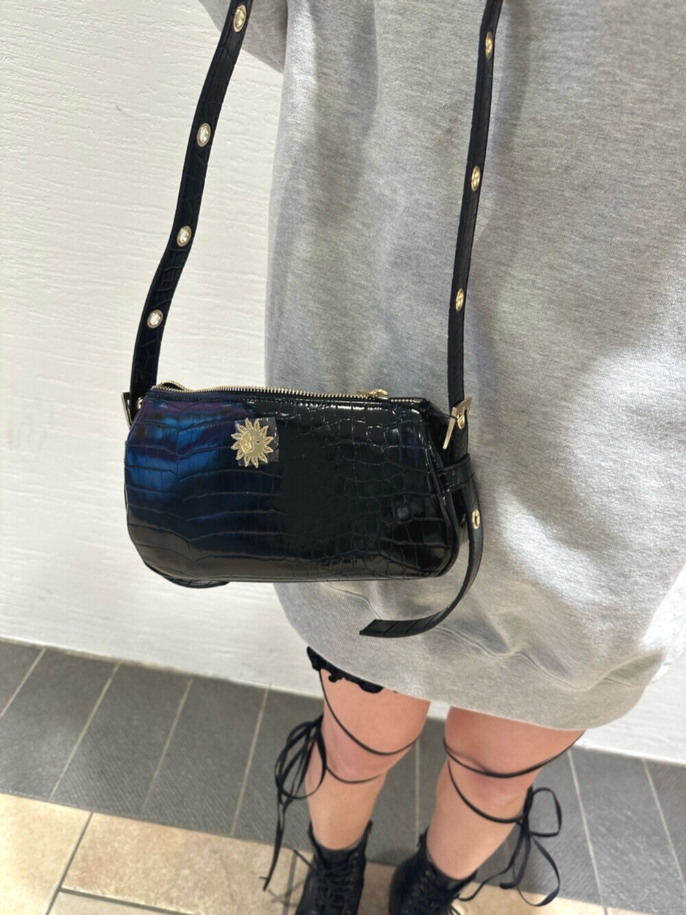 ブラック系のショルダーバッグ、ブラック系のブーツ、グレー系のスウェットを着用したレディースの冬コーディネートの8枚目の写真