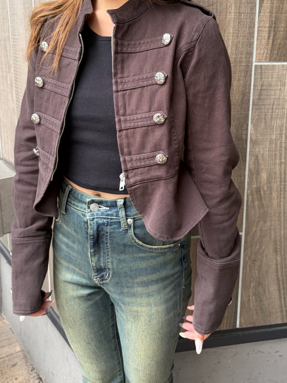 ブルー系のデニムパンツ、ブラック系のブーツ、ブラック系のミリタリージャケットを着用したレディースの秋コーディネートの5枚目の写真