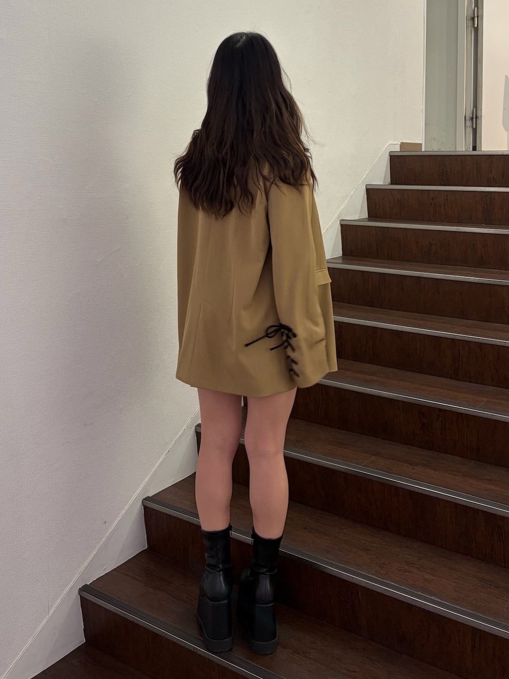 ブラウン系のテーラードジャケット、ブラック系のニット/セーター、ブラック系のその他パンツを着用したレディースの春コーディネートの3枚目の写真