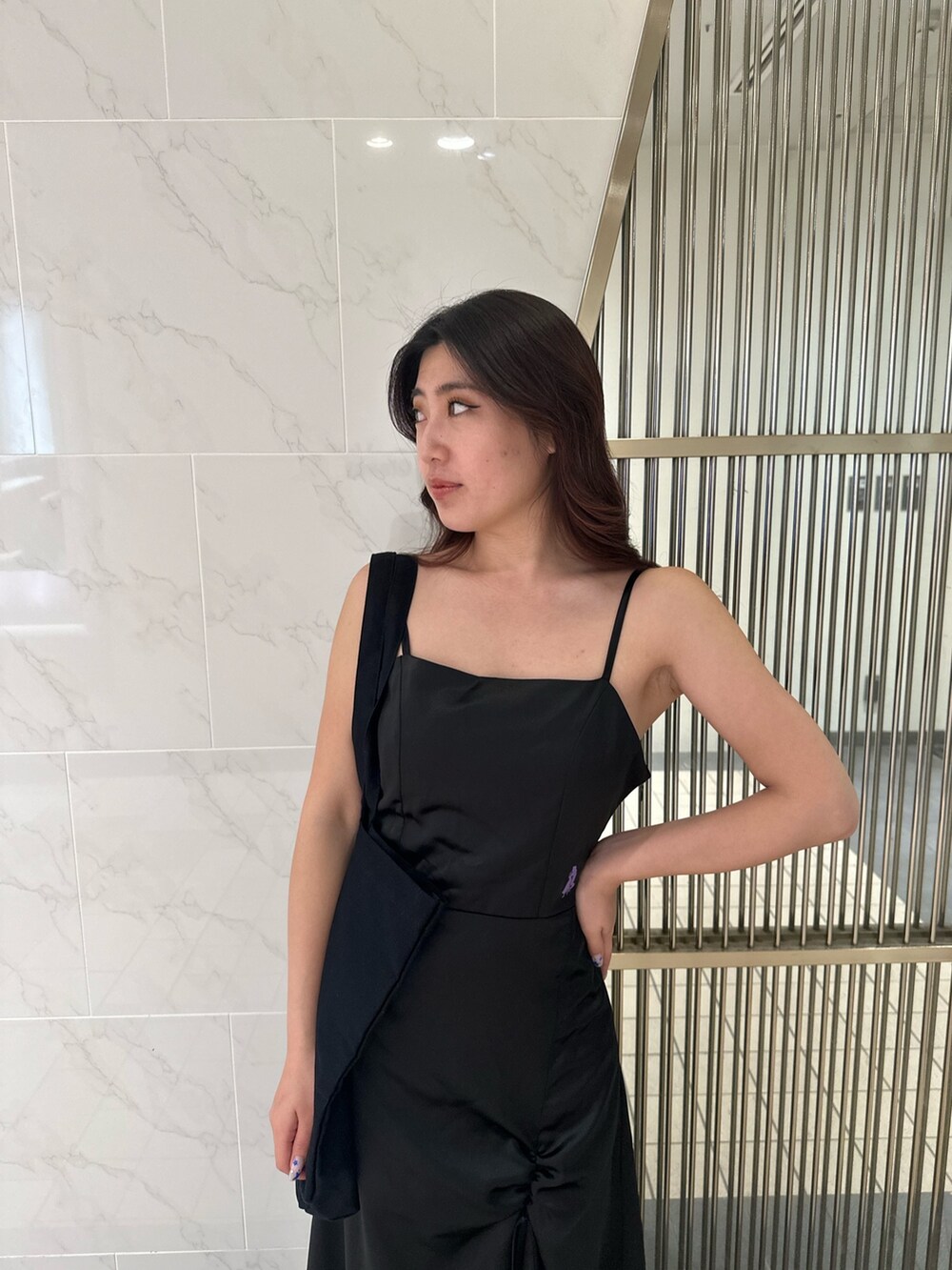 ブラック系のワンピース、ブラック系のトートバッグ、ホワイト系のサンダルを着用したレディースの夏コーディネートの6枚目の写真