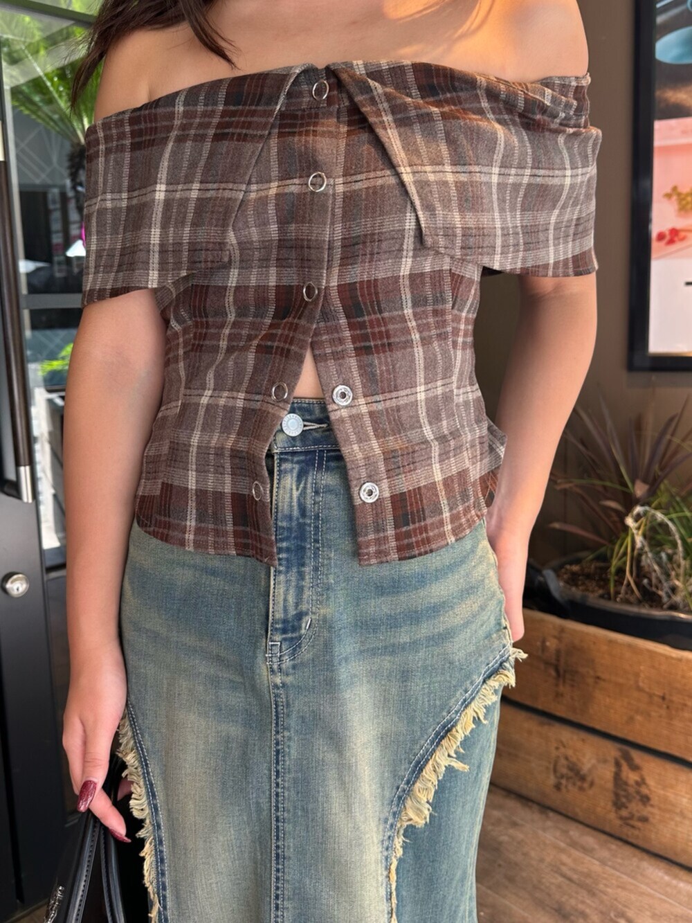 ブラック系のハンドバッグ、ブラック系のサンダル、ブルー系のデニムスカートを着用したレディースの夏コーディネートの5枚目の写真