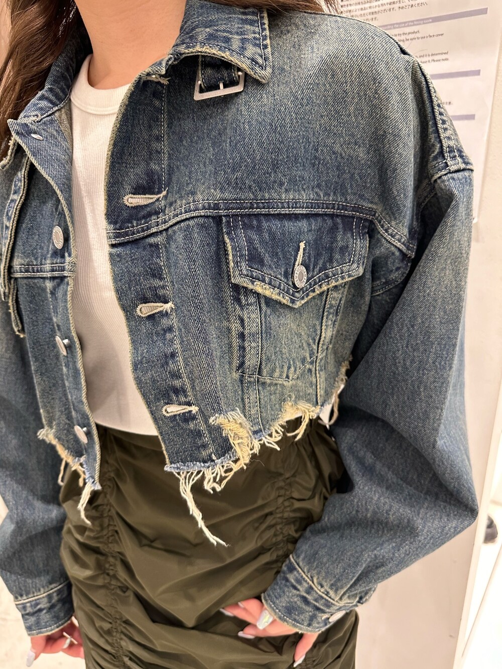 ブルー系のデニムジャケット、グリーン系のスカート、ブラック系のブーツを着用したレディースの冬コーディネートの5枚目の写真