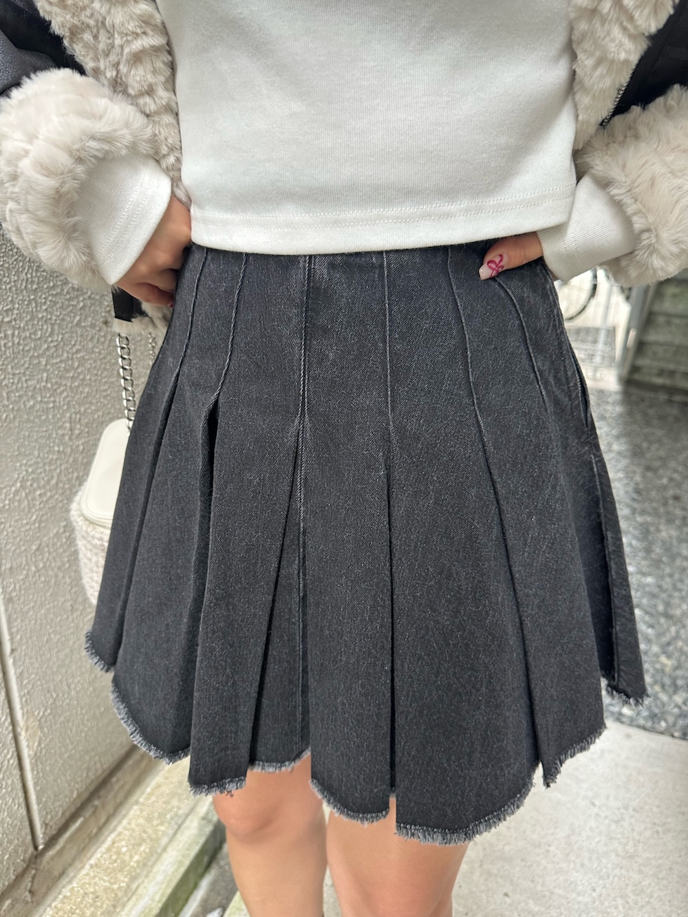 ブラック系のデニムスカート、その他のブーツ、ホワイト系のショルダーバッグを着用したレディースの秋コーディネートの7枚目の写真