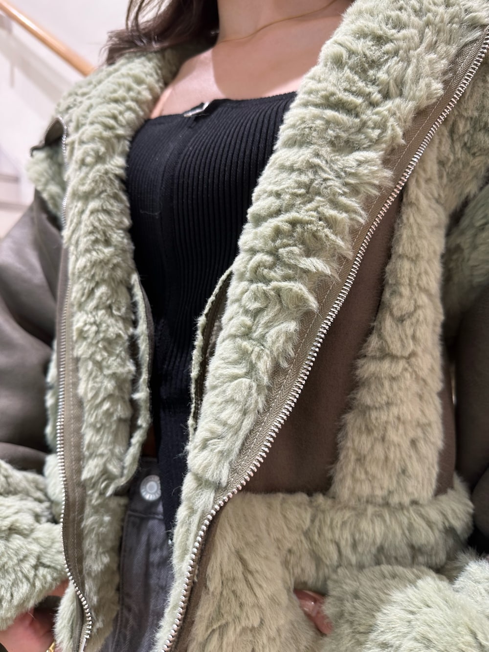 ブラック系のニット/セーター、ブラック系のデニムスカート、ブラック系のブーツを着用したレディースの夏コーディネートの5枚目の写真