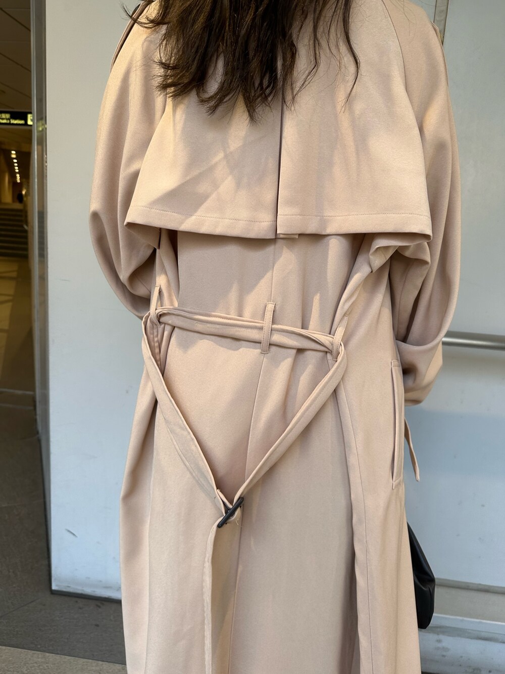 ベージュ系のトレンチコート、ブラック系のカーゴパンツ、ホワイト系のTシャツ/カットソーを着用したレディースの春コーディネートの5枚目の写真