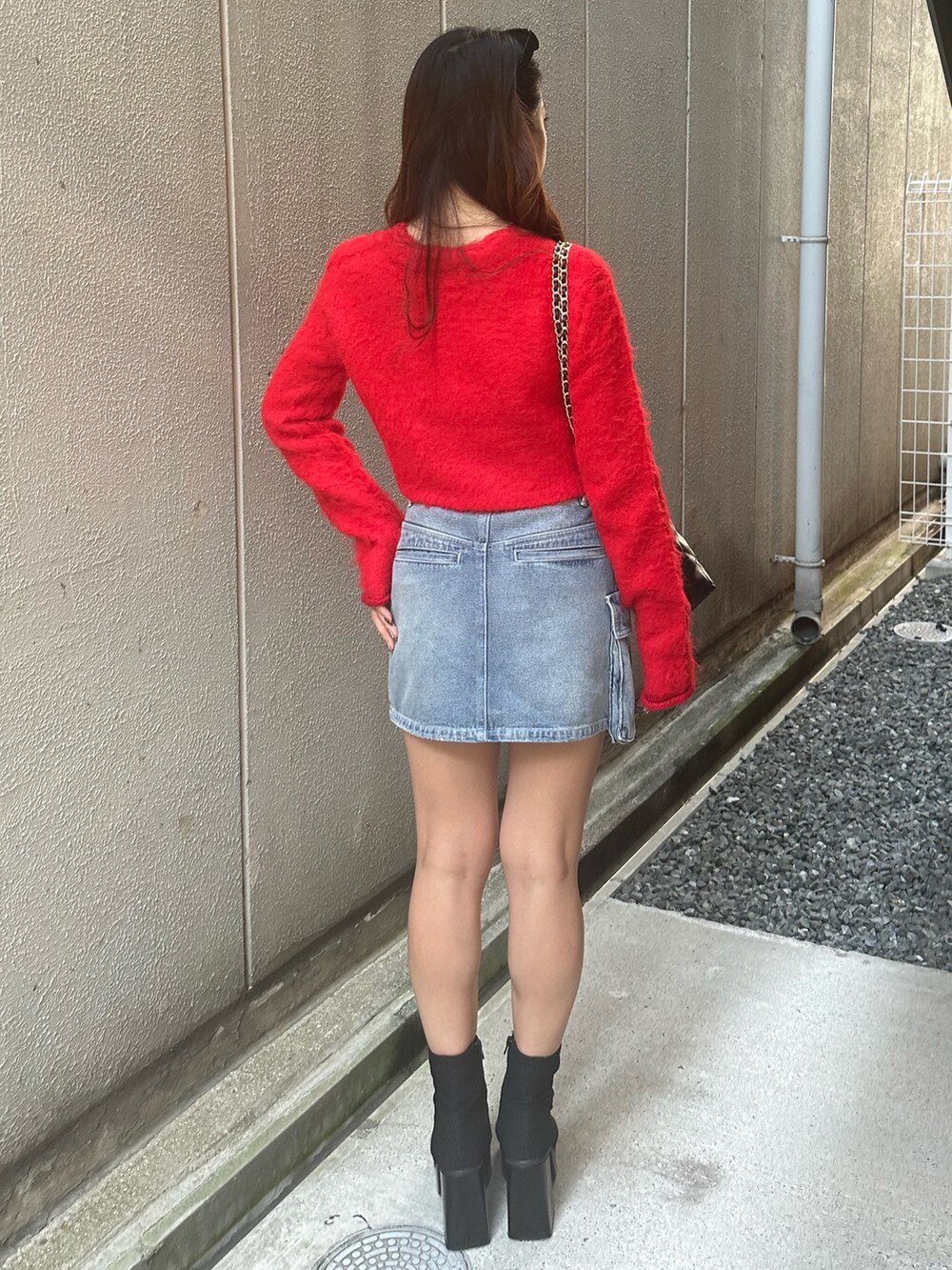 その他のブーツ、ブラック系のショルダーバッグ、レッド系のニット/セーターを着用したレディースの秋コーディネートの3枚目の写真