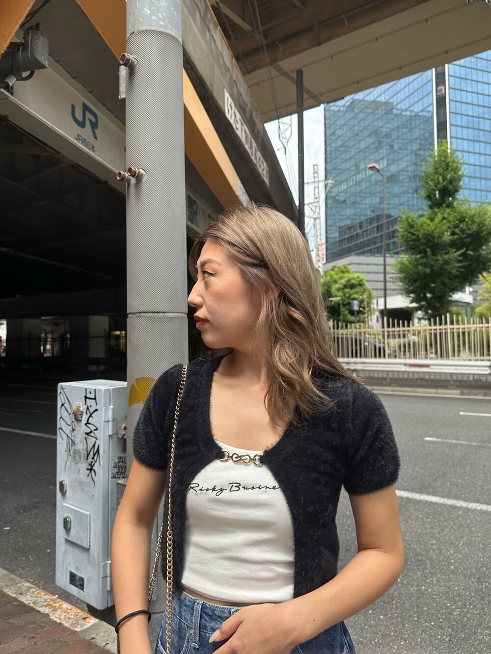 ブルー系のデニムスカート、ブラック系のサンダル、ブラック系のニット/セーターを着用したレディースの夏コーディネートの4枚目の写真