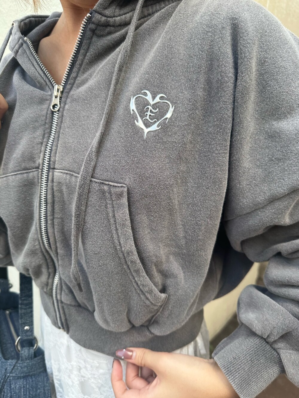 ホワイト系のスカート、グレー系のスウェット、ブラック系のブーツを着用したレディースの秋コーディネートの7枚目の写真