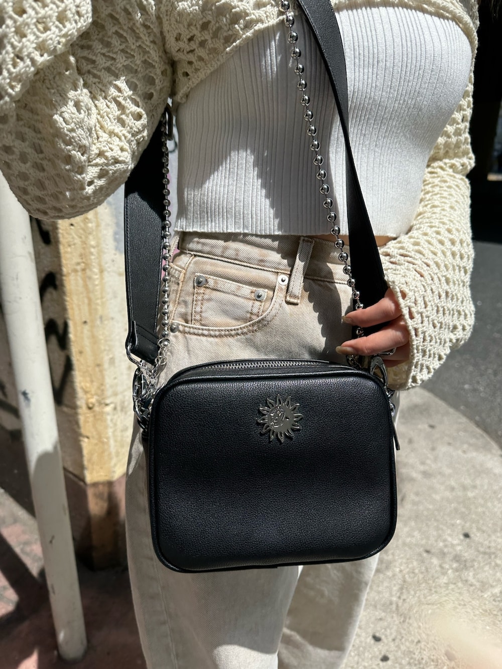 ベージュ系のデニムパンツ、ブラック系のサンダル、ホワイト系のニット/セーターを着用したレディースの春コーディネートの7枚目の写真