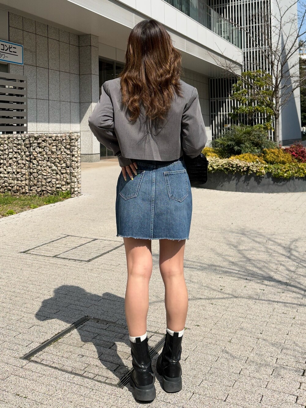 ブラック系のブーツ、グレー系のテーラードジャケット、ホワイト系のシャツ/ブラウスを着用したレディースの春コーディネートの2枚目の写真