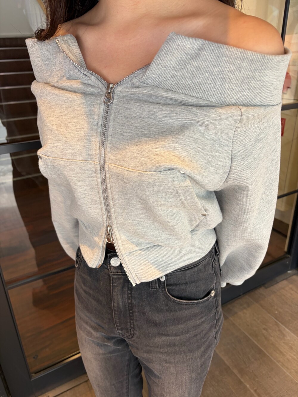 グレー系のスウェット、ブラック系のデニムパンツ、ブラック系のブーツを着用したレディースの春コーディネートの6枚目の写真