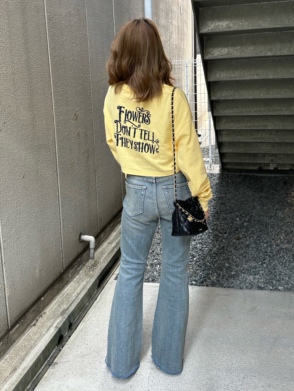 イエロー系のTシャツ/カットソー、ブルー系のデニムパンツ、ブラック系のショルダーバッグを着用したレディースの春コーディネートの3枚目の写真