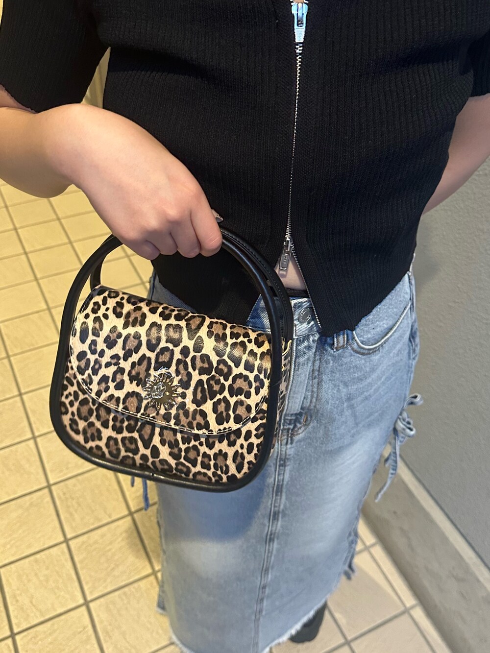 ブルー系のデニムスカート、その他のハンドバッグ、ブラック系のブーツを着用したレディースの春コーディネートの8枚目の写真