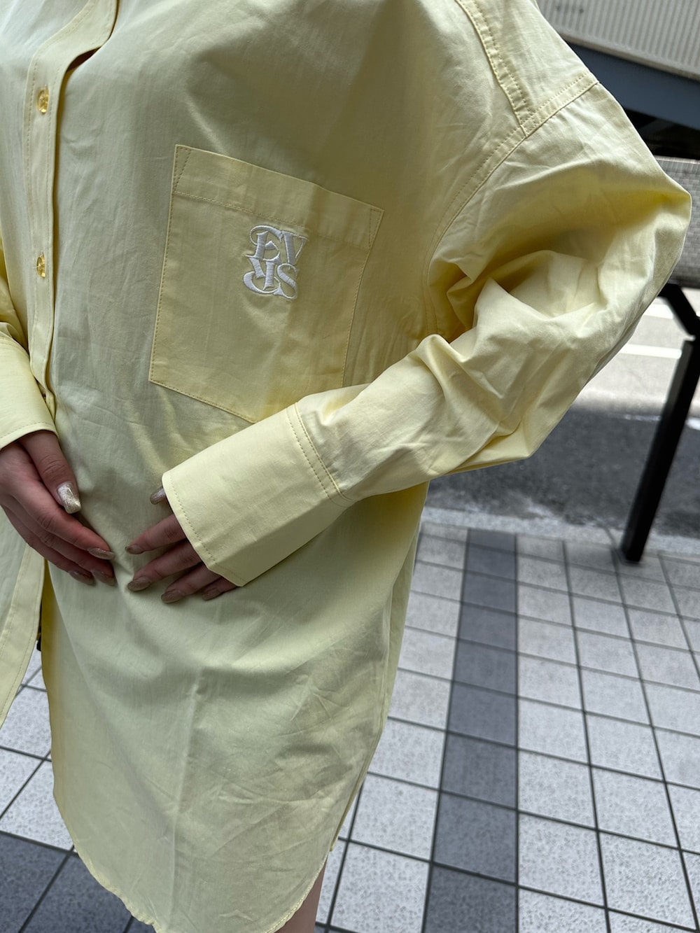 イエロー系のシャツ/ブラウス、ブラック系のブーツ、ホワイト系のショルダーバッグを着用したレディースの春コーディネートの5枚目の写真