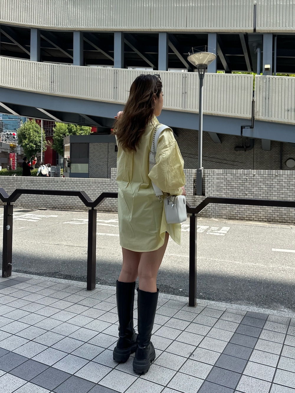 イエロー系のシャツ/ブラウス、ブラック系のブーツ、ホワイト系のショルダーバッグを着用したレディースの春コーディネートの3枚目の写真