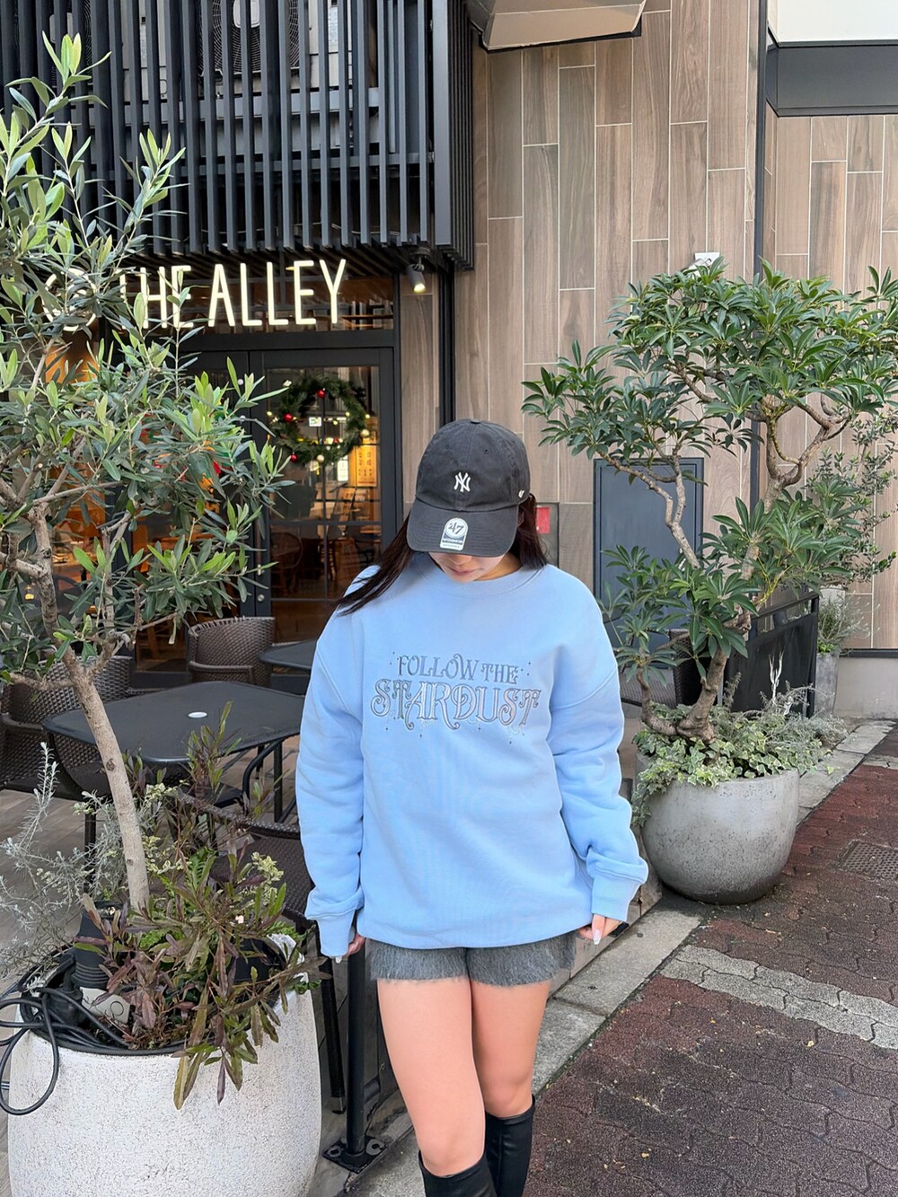 ブラック系のブーツ、ブルー系のスウェット、グレー系のつなぎ/オールインワンを着用したレディースの冬コーディネートの5枚目の写真