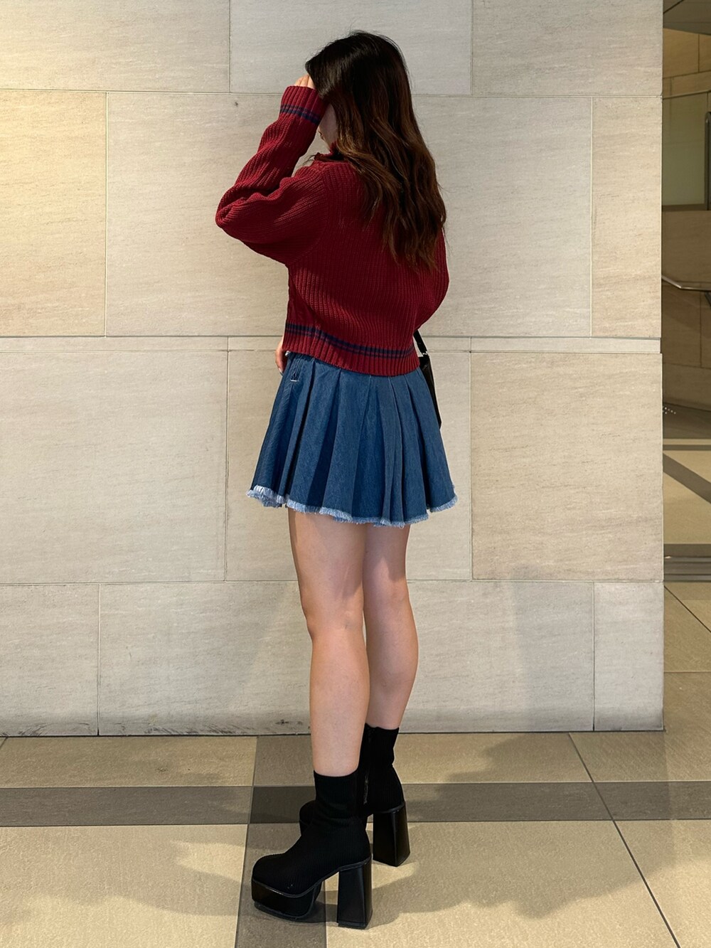 ブルー系のデニムスカート、レッド系のニット/セーター、その他のブーツを着用したレディースの夏コーディネートの3枚目の写真