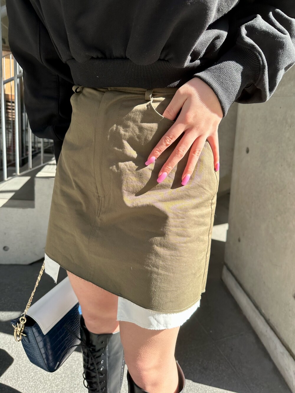 ブラック系のスウェット、ブラック系のブーツ、ブルー系のショルダーバッグを着用したレディースの冬コーディネートの5枚目の写真