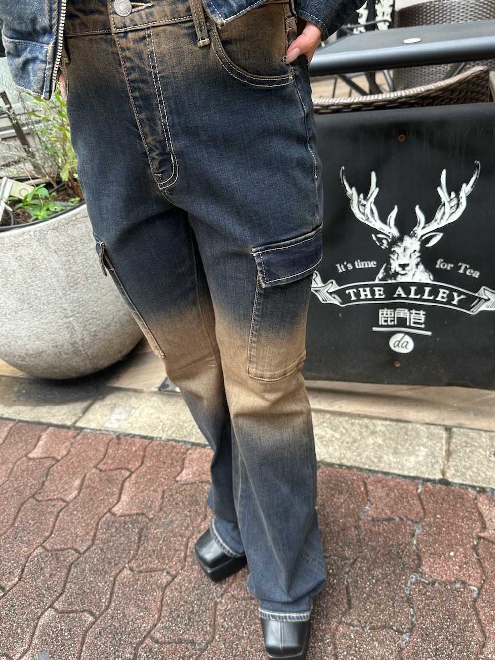 ブルー系のデニムパンツ、ブルー系のデニムジャケット、ブラック系のブーツを着用したレディースの秋コーディネートの7枚目の写真