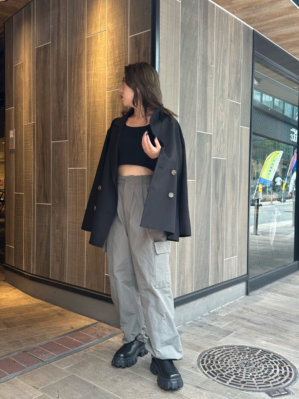 グレー系のカーゴパンツ、ブラック系のTシャツ/カットソー、ブラック系のブーツを着用したレディースの秋コーディネートの2枚目の写真