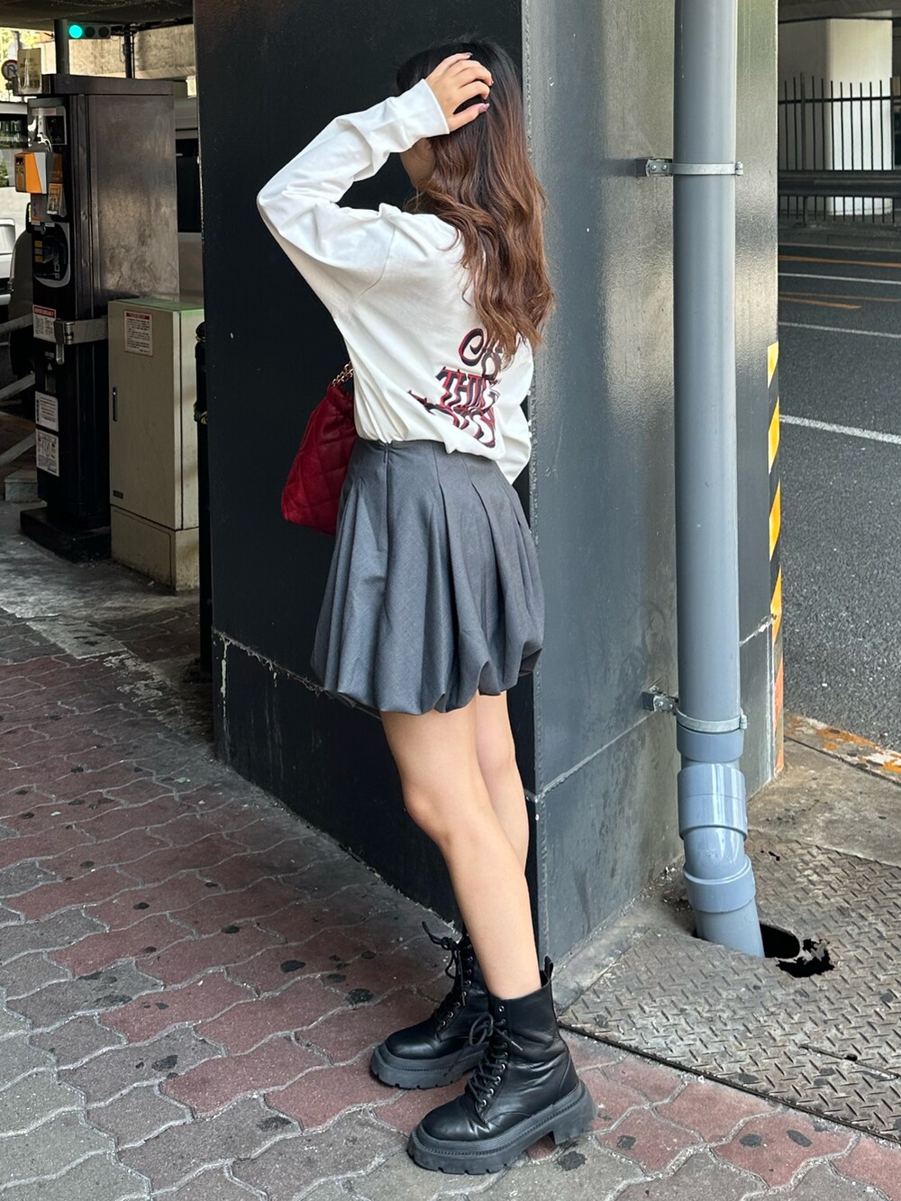 ホワイト系のTシャツ/カットソー、グレー系のスカート、ブラック系のブーツを着用したレディースの秋コーディネートの2枚目の写真