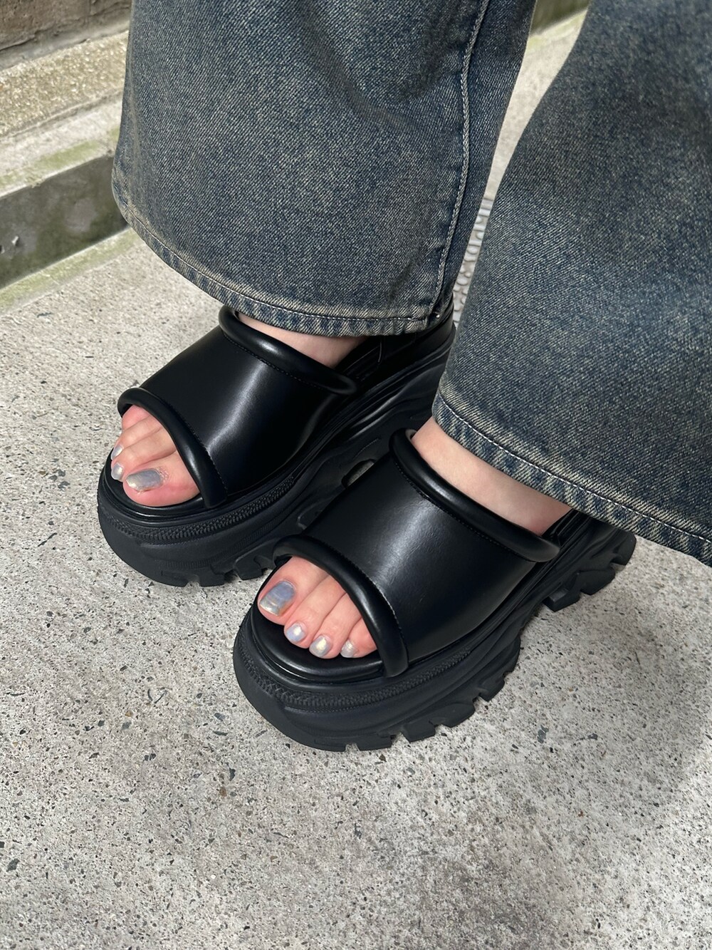 ブルー系のデニムパンツ、ブラック系のサンダル、ブルー系のキャミソールを着用したレディースの夏コーディネートの7枚目の写真