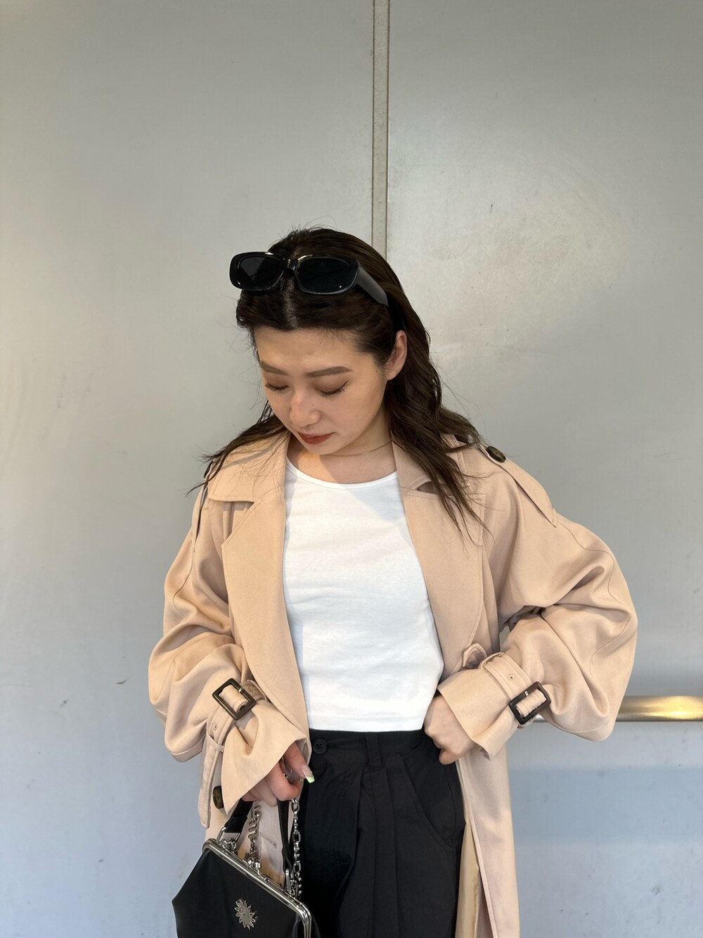 ベージュ系のトレンチコート、ブラック系のカーゴパンツ、ホワイト系のTシャツ/カットソーを着用したレディースの春コーディネートの3枚目の写真