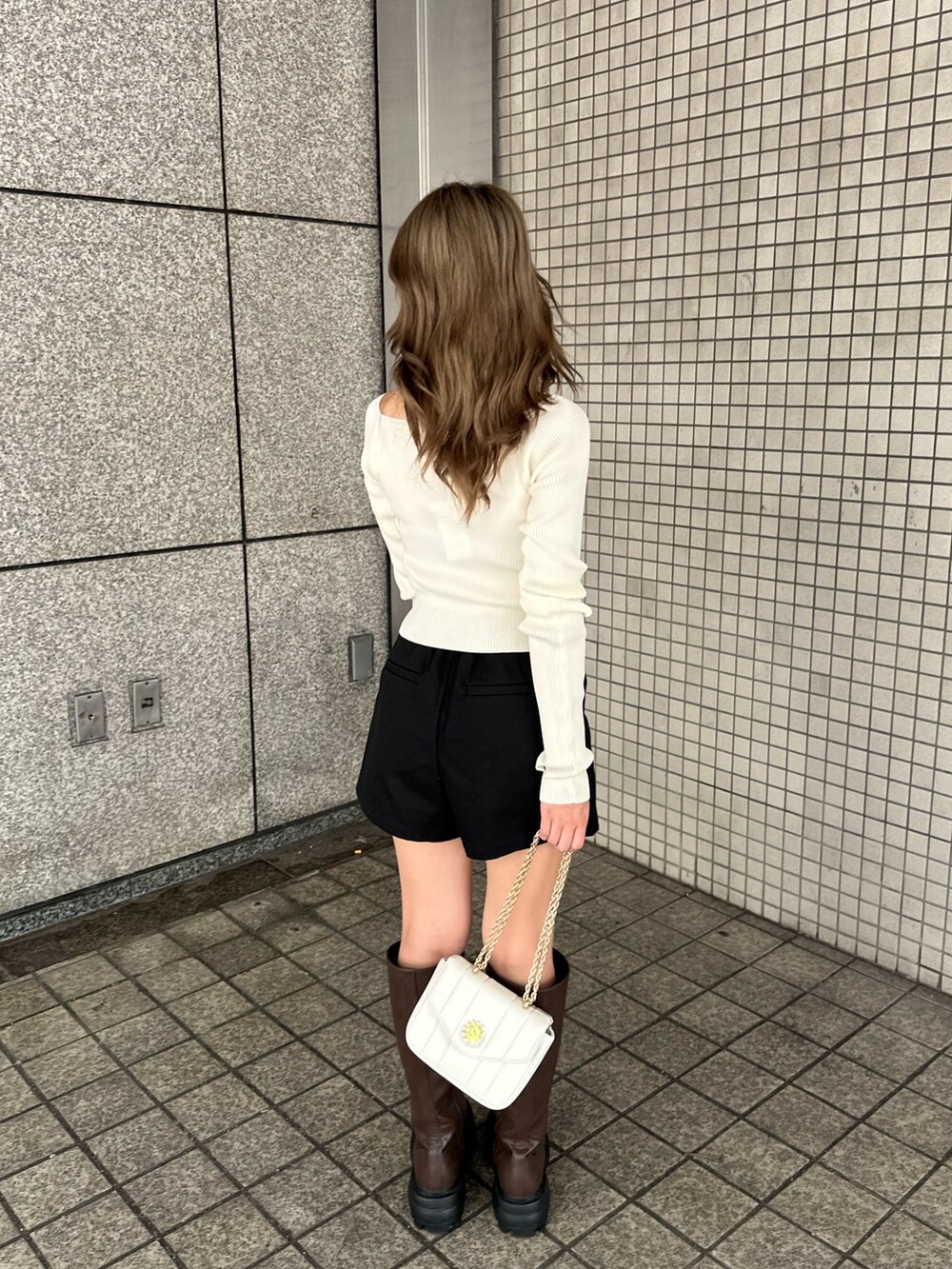 ブラック系のその他パンツ、ホワイト系のショルダーバッグ、ブラウン系のブーツを着用したレディースの夏コーディネートの3枚目の写真