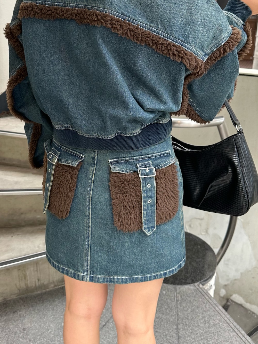 ブルー系のブルゾン、ブルー系のデニムスカート、その他のブーツを着用したレディースの秋コーディネートの7枚目の写真