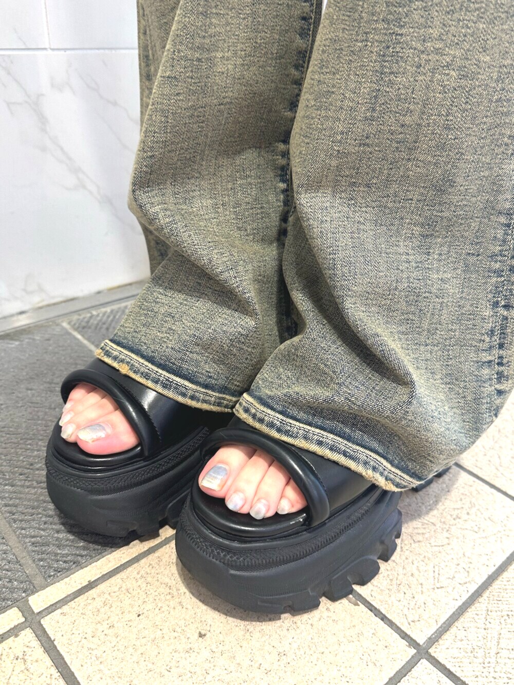ブラック系のサンダル、ブルー系のデニムパンツ、ブラック系のシャツ/ブラウスを着用したレディースの夏コーディネートの8枚目の写真
