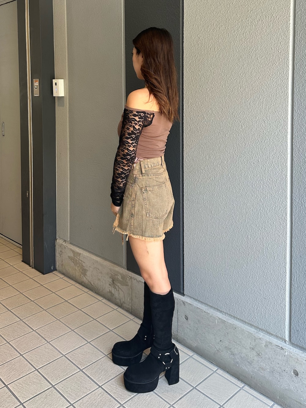 ブルー系のデニムパンツ、ブラック系のブーツ、ブラウン系のTシャツ/カットソーを着用したレディースの秋コーディネートの2枚目の写真