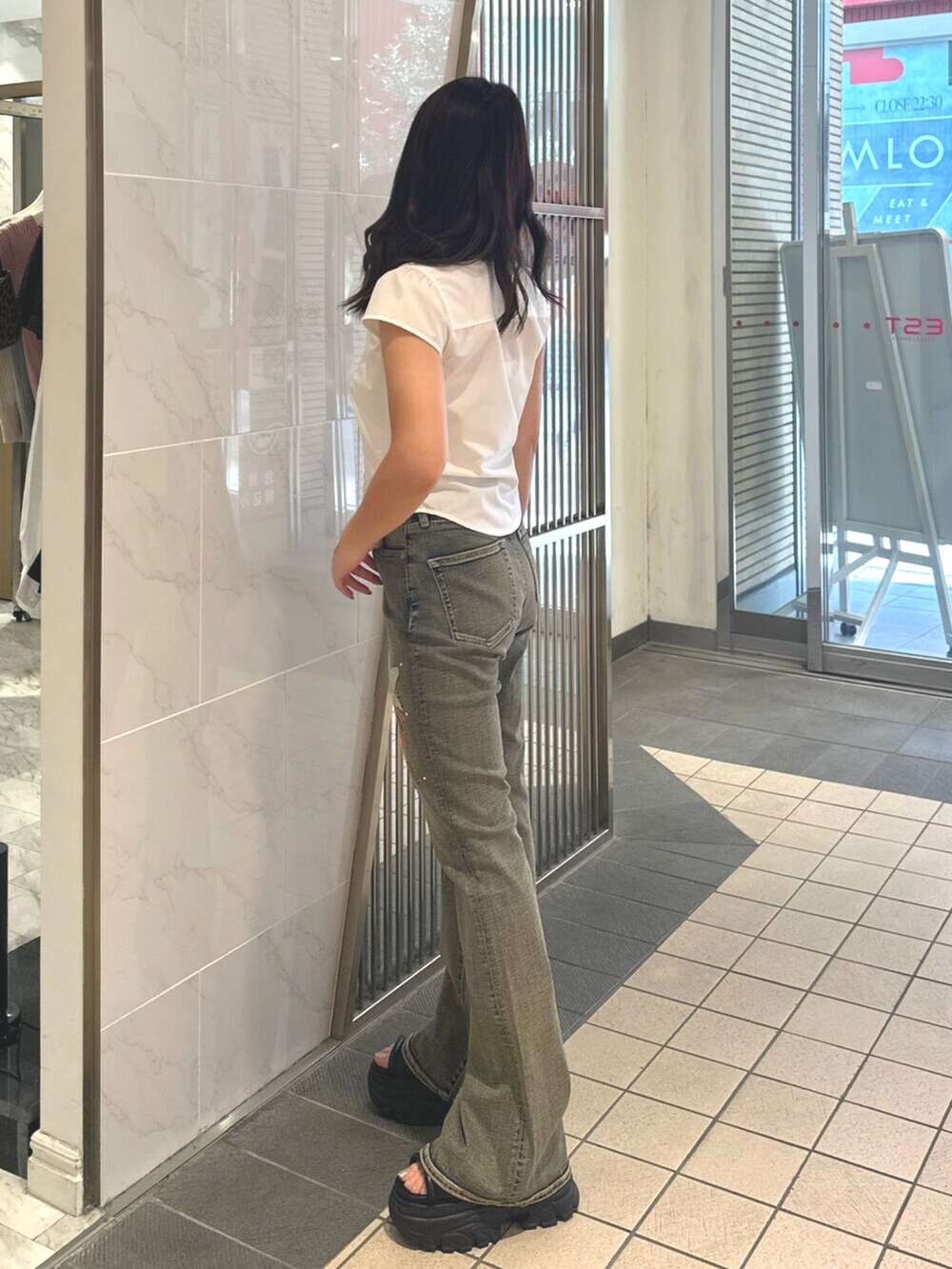 ブラック系のサンダル、ブルー系のデニムパンツ、ホワイト系のシャツ/ブラウスを着用したレディースの夏コーディネートの2枚目の写真