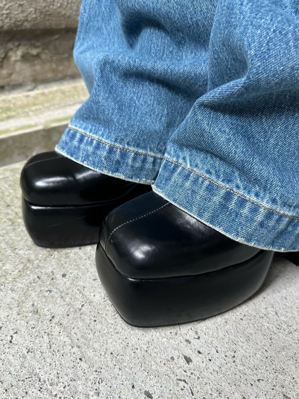 ブラック系のショルダーバッグ、ブラック系のサンダル、ブルー系のデニムパンツを着用したレディースの春コーディネートの8枚目の写真