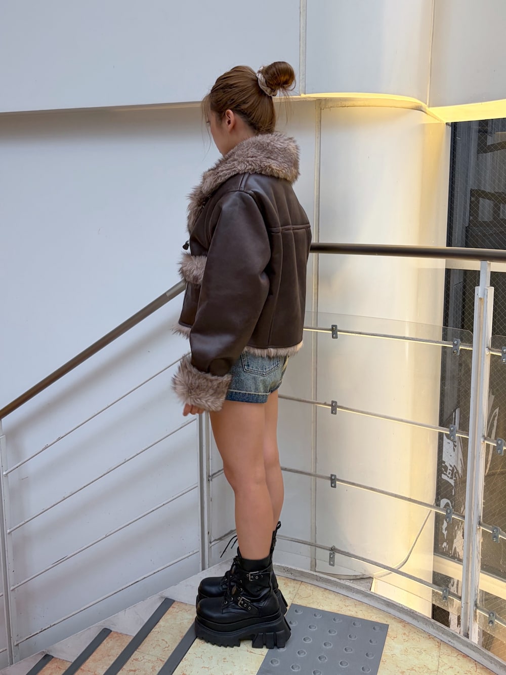 ブルー系のその他パンツ、ブラック系のブーツ、ブラウン系のブルゾンを着用したレディースの秋コーディネートの2枚目の写真