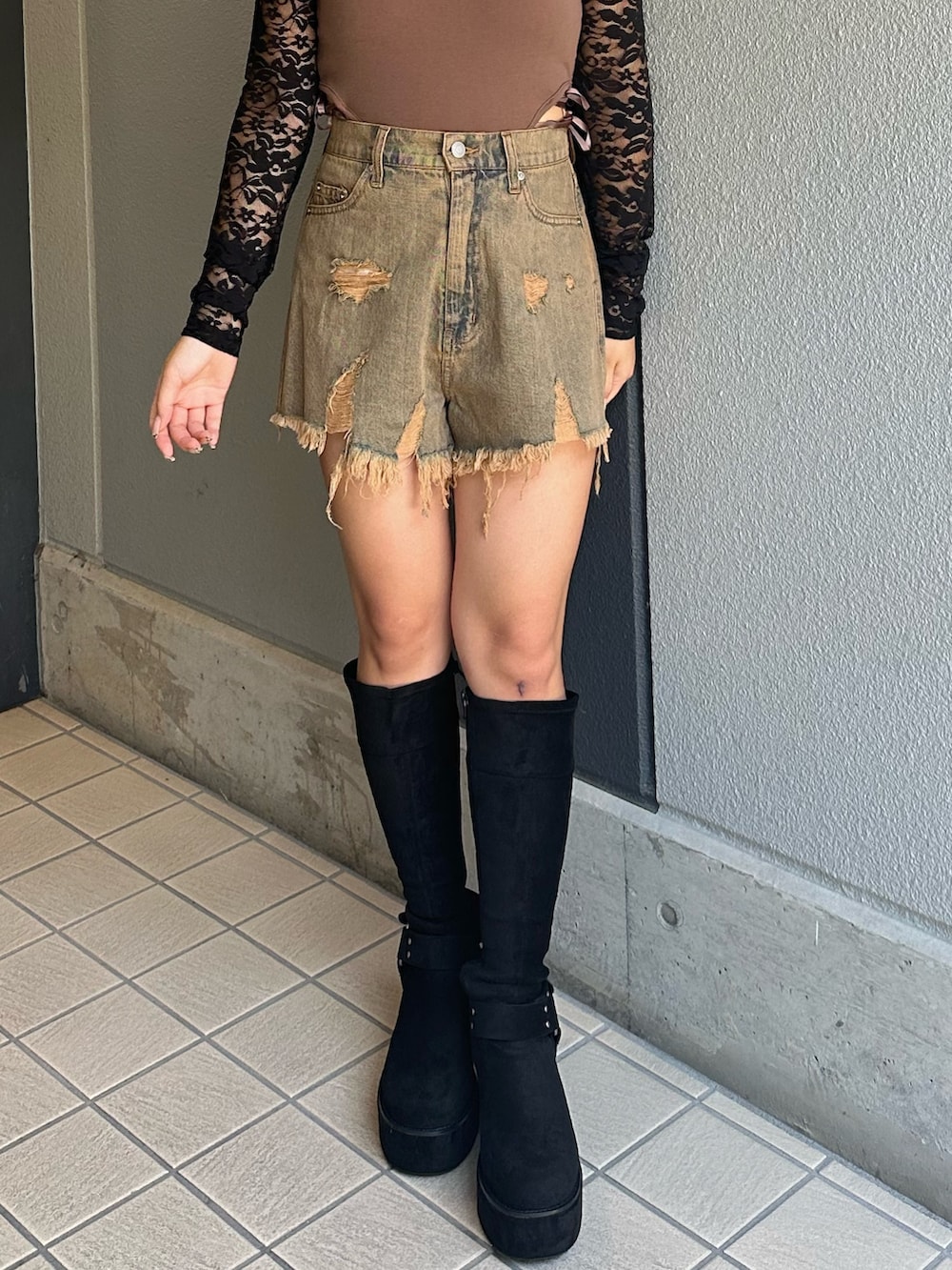 ブルー系のデニムパンツ、ブラック系のブーツ、ブラウン系のTシャツ/カットソーを着用したレディースの秋コーディネートの5枚目の写真