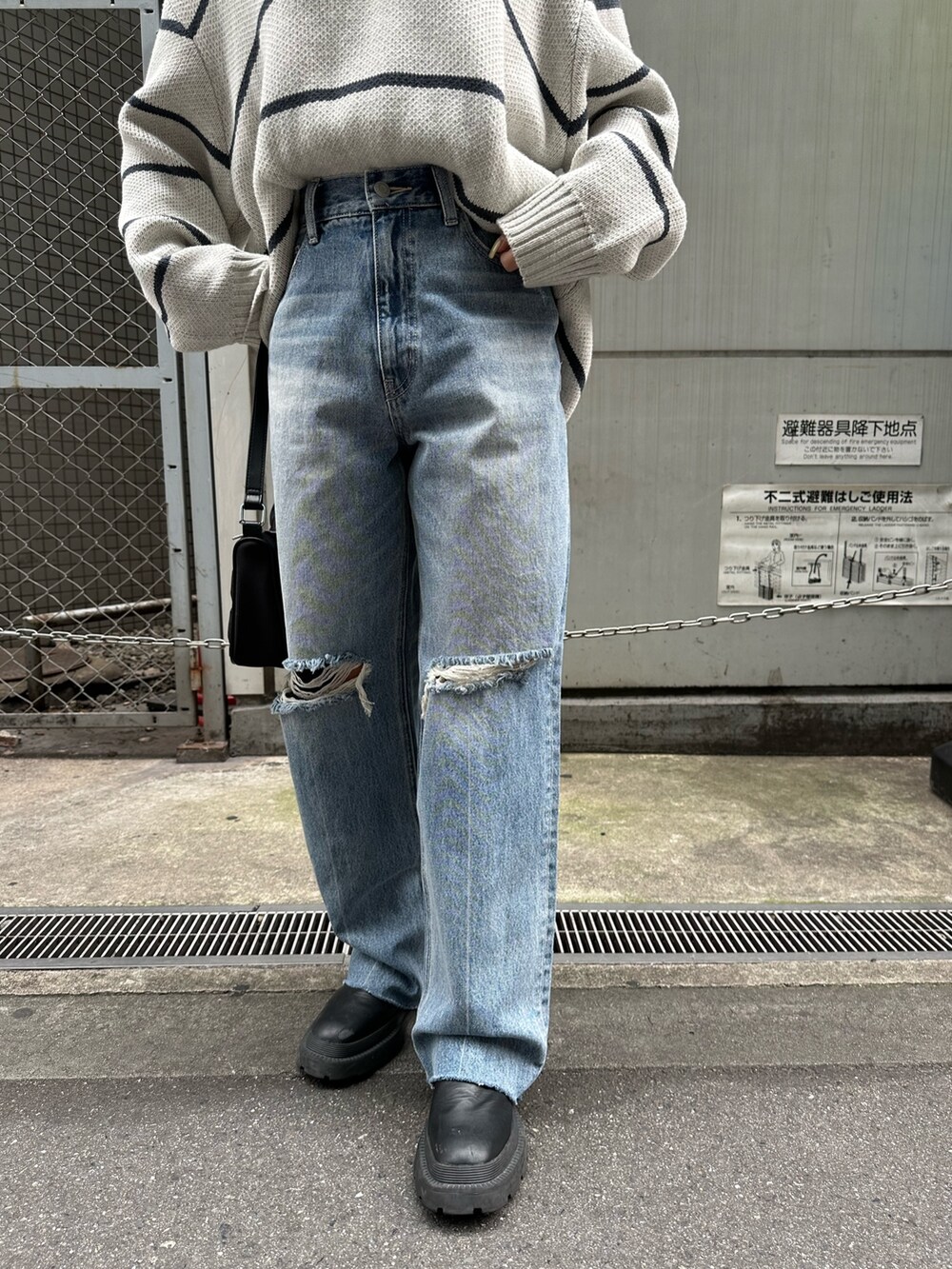 ブラック系のデニムパンツ、ブラック系のハンドバッグ、その他のニット/セーターを着用したレディースの夏コーディネートの6枚目の写真