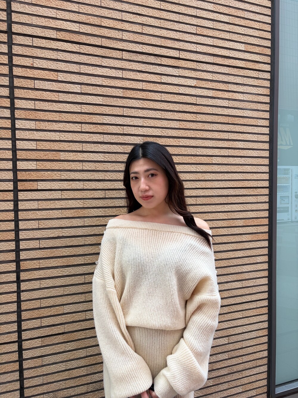 ブラック系のブーツ、ホワイト系のワンピース、ブラック系のハンドバッグを着用したレディースの冬コーディネートの5枚目の写真