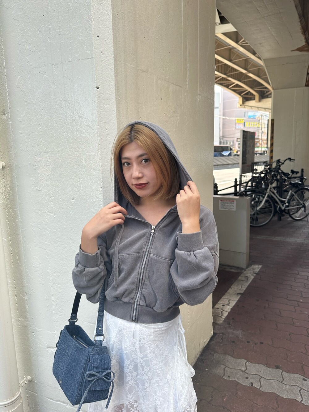 ホワイト系のスカート、グレー系のスウェット、ブラック系のブーツを着用したレディースの秋コーディネートの6枚目の写真