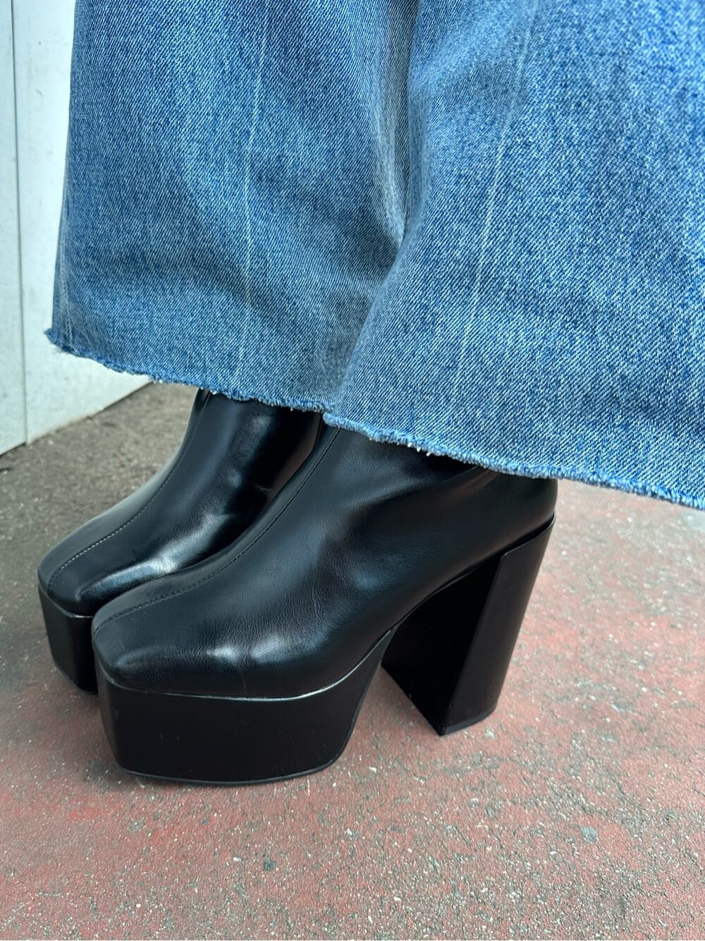 ブラック系のブーツ、ブルー系のニット/セーター、ブルー系のデニムパンツを着用したレディースの秋コーディネートの7枚目の写真