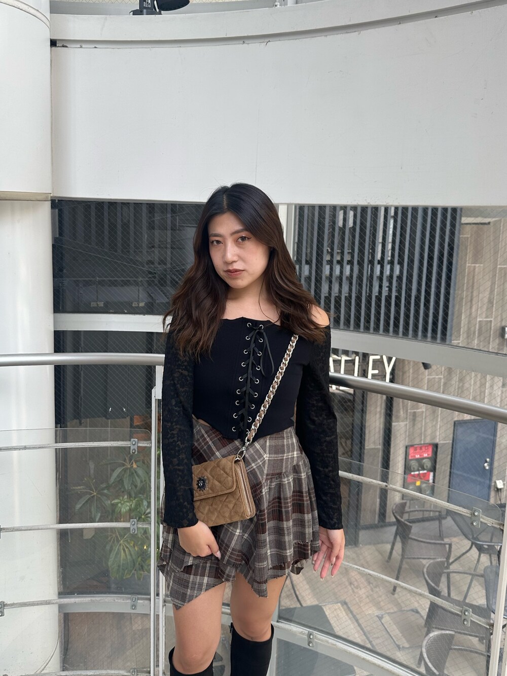 ベージュ系のハンドバッグ、ブラック系のTシャツ/カットソー、ブラック系のブーツを着用したレディースの秋コーディネートの4枚目の写真