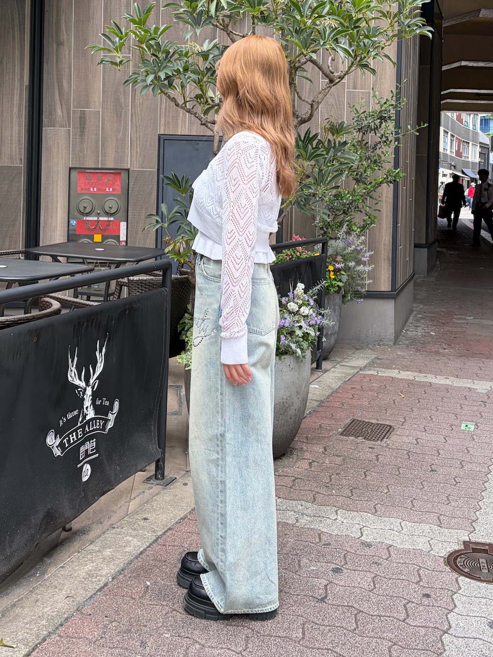 ブルー系のデニムパンツ、ホワイト系のカーディガン/ボレロを着用したレディースの春コーディネートの2枚目の写真