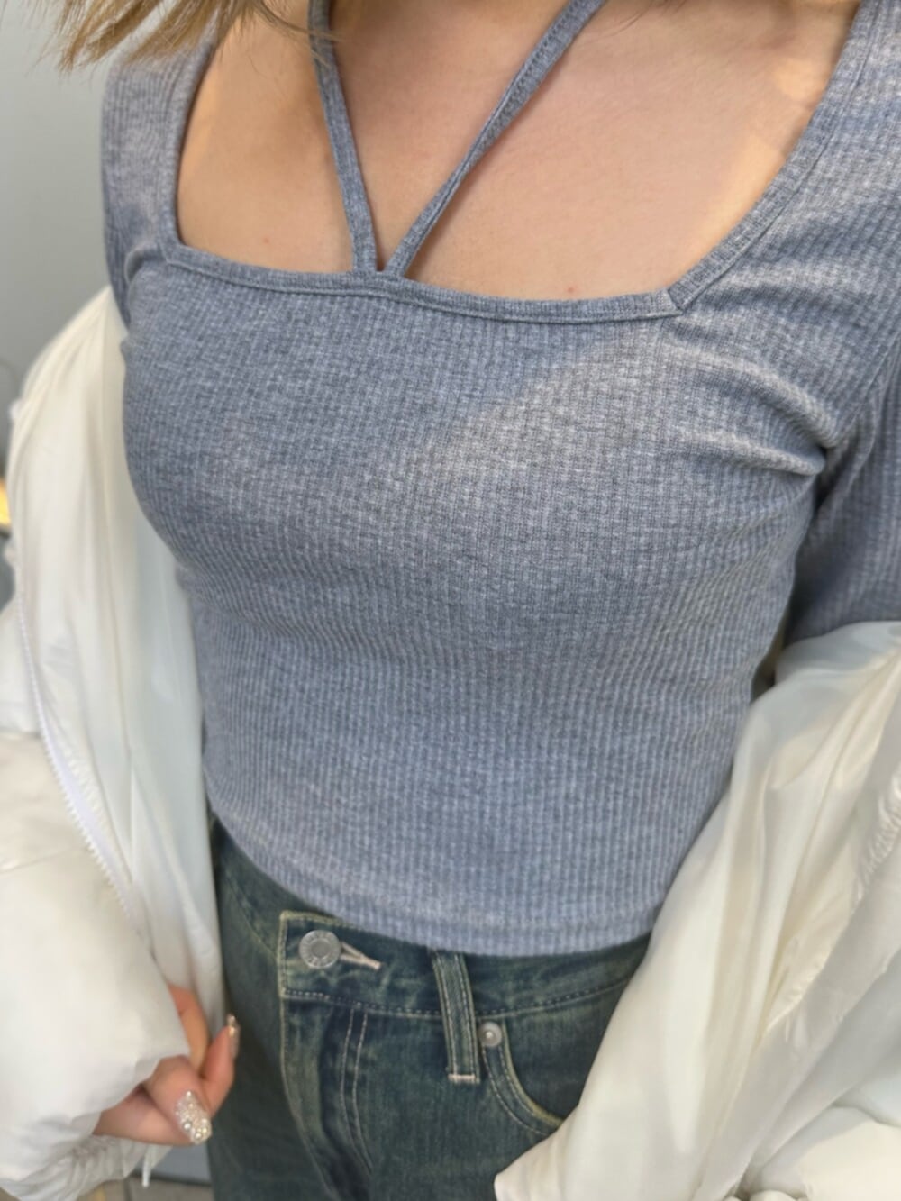 ブルー系のデニムパンツ、ホワイト系のブルゾン、グレー系のTシャツ/カットソーを着用したレディースの冬コーディネートの6枚目の写真