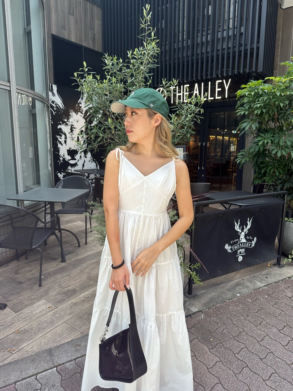 ホワイト系のワンピース、ブラック系のハンドバッグ、ブラック系のサンダルを着用したレディースの夏コーディネートの4枚目の写真